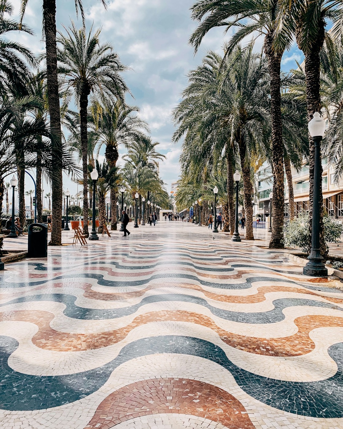 The wave mosaic of the Explanada de España under its palm trees